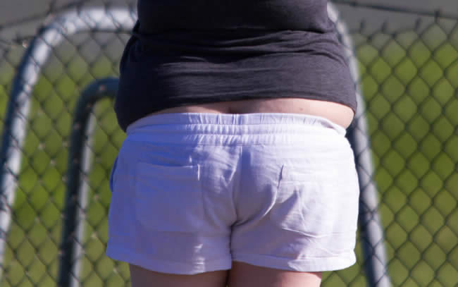 Woman spilling out of the top of her shorts