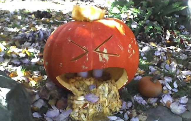 Jack-o-lantern vomiting pumpkin seeds and pulp